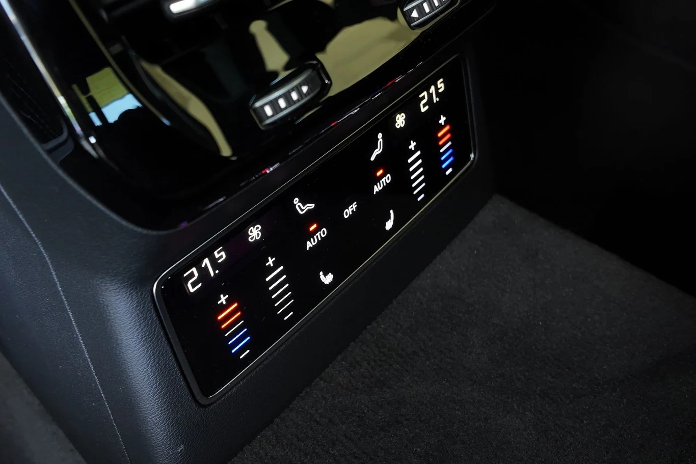 Audi A6 opcjonalnie jest dostępne z czterostrefową klimatyzacją. Panel dotykowy kontroli klimatyzacji w samochodzie z wyświetlaczami temperatury, ikonami nawiewu oraz regulacją poziomu chłodzenia i ogrzewania, otoczony czarną tapicerką wnętrza.