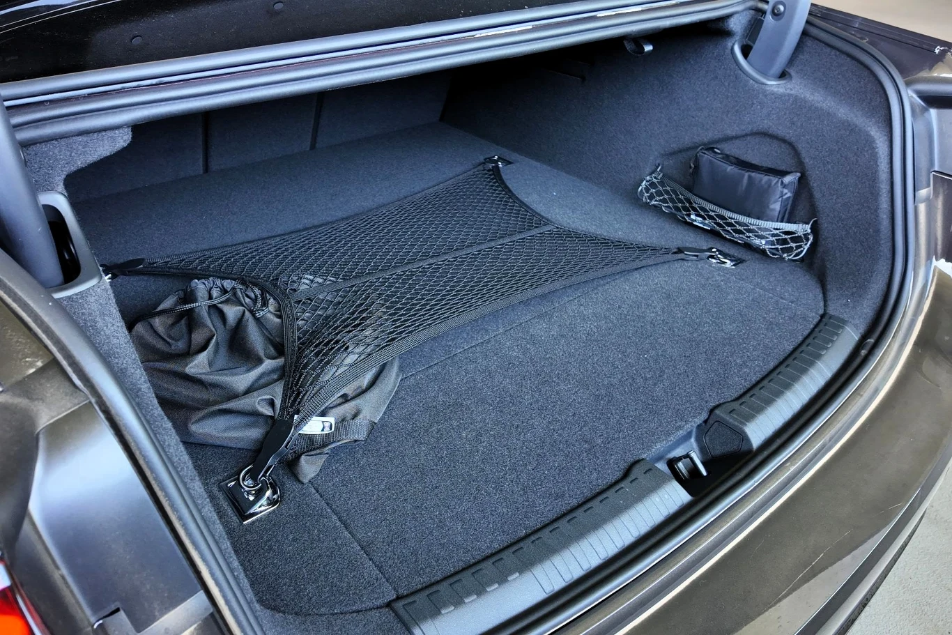 Bagażnik Audi A6 w sedanie mieści do 492 litrów. W kombi z kolei może to być do 503 litrów. Pojemność uzależniona jest jednak od napędu. Otwarty bagażnik samochodu z widoczną siatką zabezpieczającą do przewożenia przedmiotów oraz kieszenią boczną na akcesoria, wnętrze bagażnika jest czyste i przestronne.