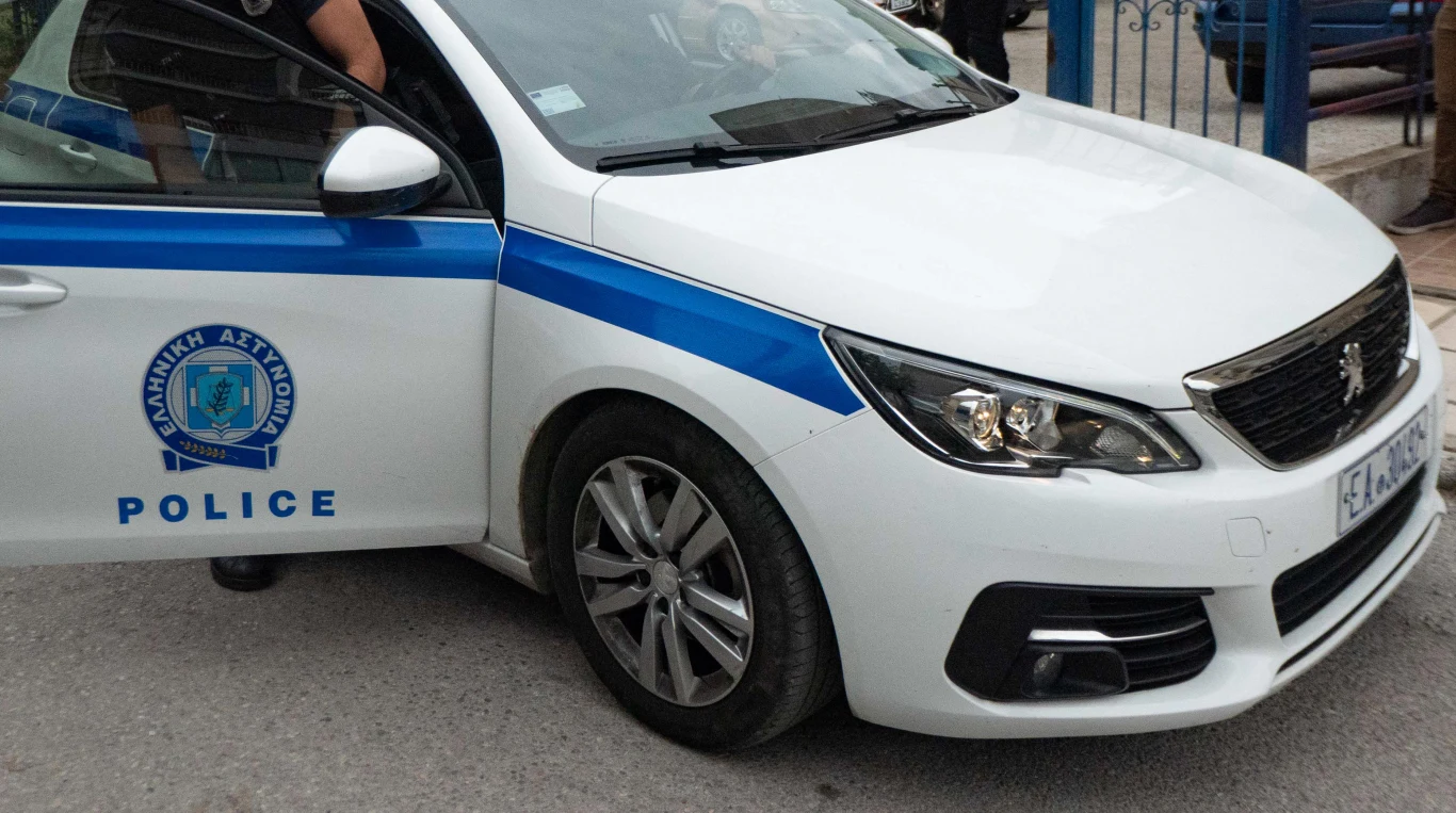 Pięć osób aresztowanych w związku z zabójstwem polskiego profesora Radiowóz policyjny z oznaczeniami i niebieskim paskiem, zaparkowany na ulicy, lekko otwarte drzwi kierowcy, fragment osoby siedzącej wewnątrz.