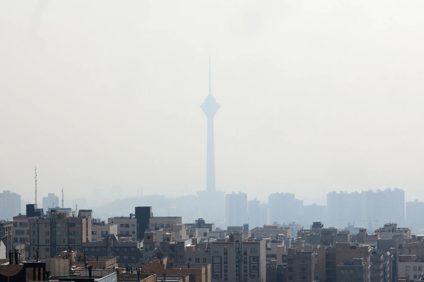 Teheran na granicy dnia zero. Walka z niedoborem wody w Iranie Panorama miasta z wyraźnie widoczną wysoką wieżą telewizyjną na tle silnie zamglonego powietrza, liczne budynki mieszkalne i biurowe w dolnej części kadru, ograniczona widoczność spowodowana przez smog.
