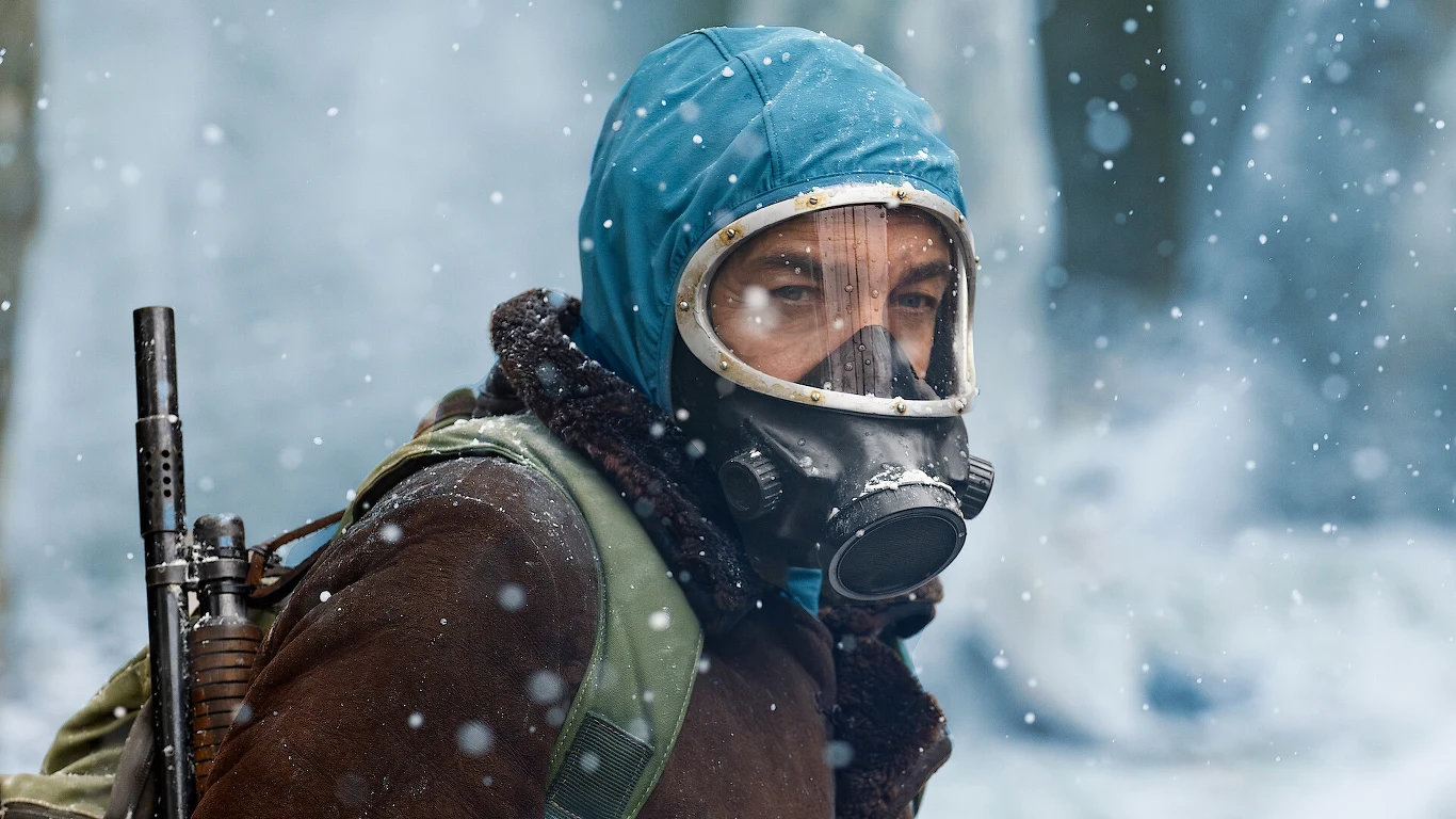 Zastosowanie AI w "Eternaucie" może być początkiem nowego trendu w produkcjach telewizyjnych i filmowych Człowiek w masce gazowej i niebieskiej kurtce z kapturem, otoczony wirującym śniegiem, niesie na plecach plecak oraz broń, wygląda na przygotowanego do trudnych warunków w zimowym, postapokaliptycznym otoczeniu.