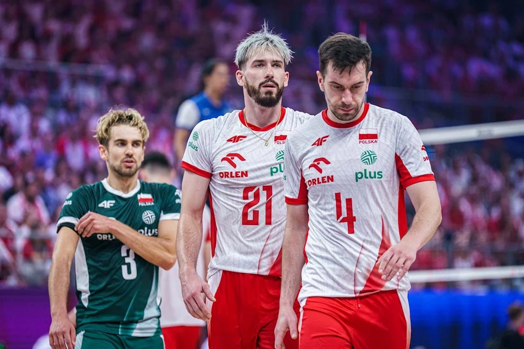 Liga Narodów siatkarzy. "Biało-Czerwoni" chcą zatrzeć złe wrażenie z porażki z Kubą Polscy siatkarze w stroju meczowym idący po boisku podczas zawodów, wokół widoczna rozmyta publiczność, zbliżenie na zawodników w białych koszulkach z czerwonymi akcentami i numerami 21 oraz 4.