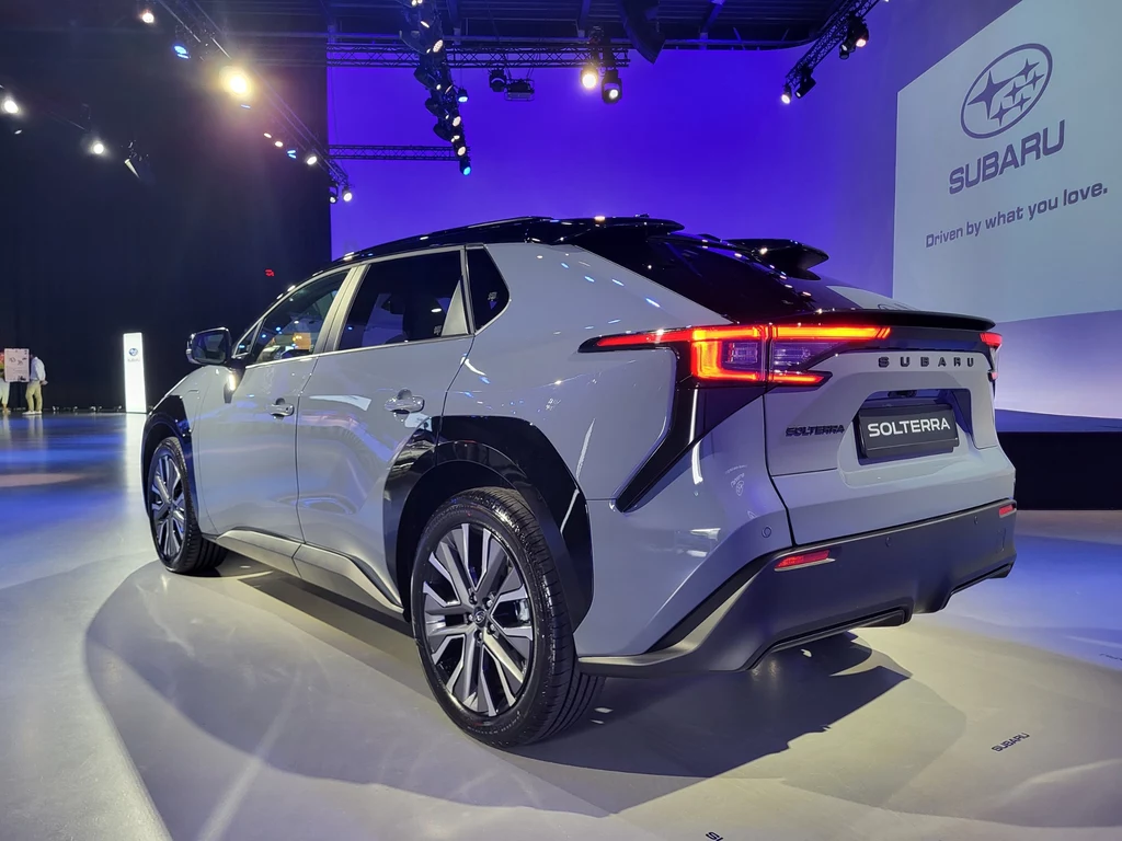 Elektryczny SUV Subaru Solterra w jasnym oświetleniu ekspozycyjnym, z nowoczesnym designem tylnych świateł, widocznym logo marki i wyraźnie oznaczonym emblematem modelu.