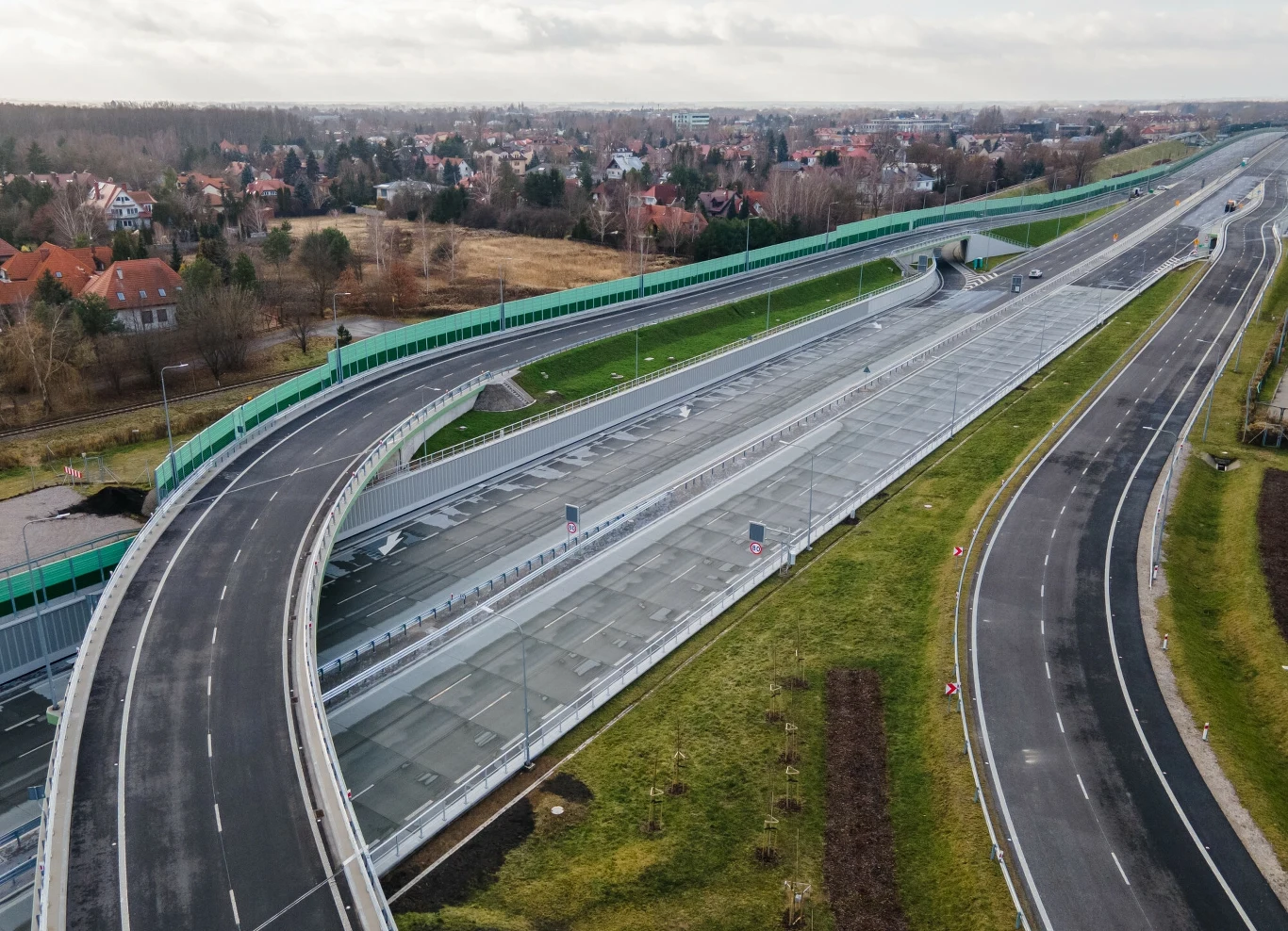 Na Południowej Obwodnicy Warszawy powstaną dodatkowe ekrany akustyczne Nowoczesny węzeł drogowy z przeszklonymi ekranami dźwiękochłonnymi, przebiegający przez tereny mieszkaniowe, otoczony zielenią i zabudową jednorodzinną.