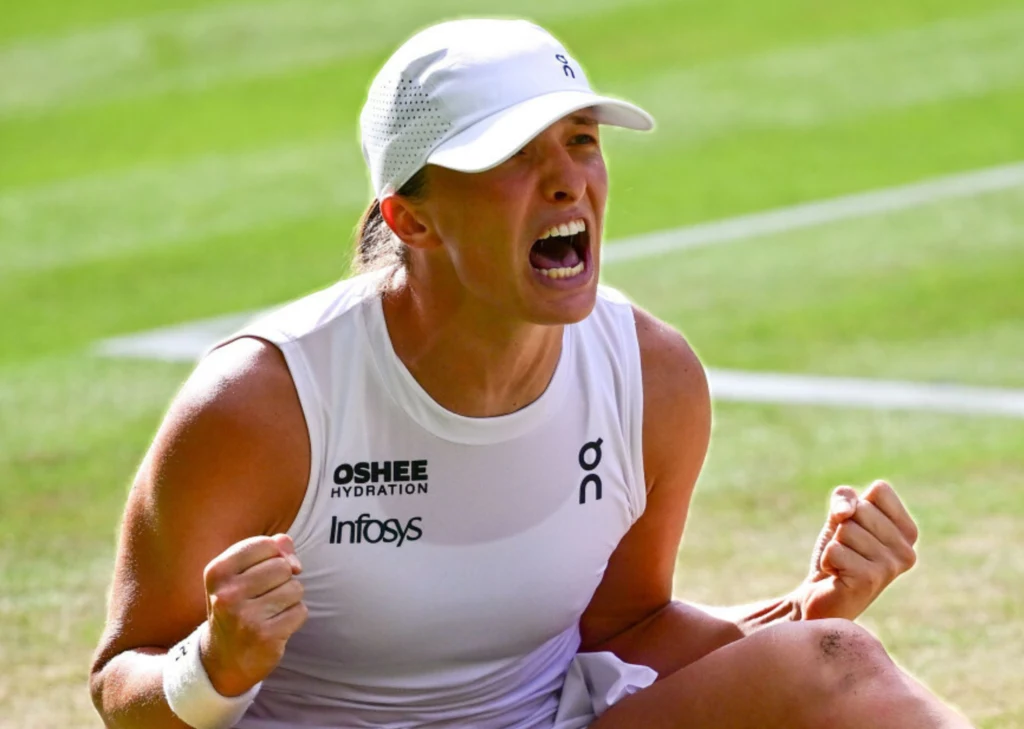 Iga Świątek podczas tegorocznego Wimbledonu Zawodniczka tenisowa w białym stroju świętuje sukces na korcie trawiastym, wyrażając silne emocje zaciśniętymi pięściami i okrzykiem triumfu, kontrastujące z intensywną rywalizacją widoczną w jej postawie i mimice.