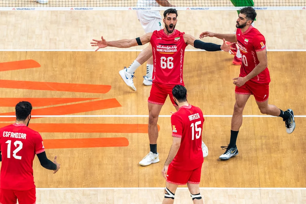 Liga Narodów siatkarzy. Iran ograł Bułgarię Siatkarze w czerwonych strojach drużyny narodowej świętują zdobycie punktu na boisku, gestykulując i okazując emocje. Zawodnicy są w ruchu, a na ich twarzach widoczne są radość i determinacja.