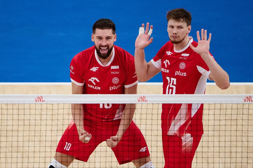 Jakub Kochanowski i Bartosz Bednorz Dwóch siatkarzy w czerwonych koszulkach reprezentacji Polski cieszy się na boisku po zdobytym punkcie, jeden zawodnik energicznie zaciska pięści i wyraża radość, drugi unosi ręce.