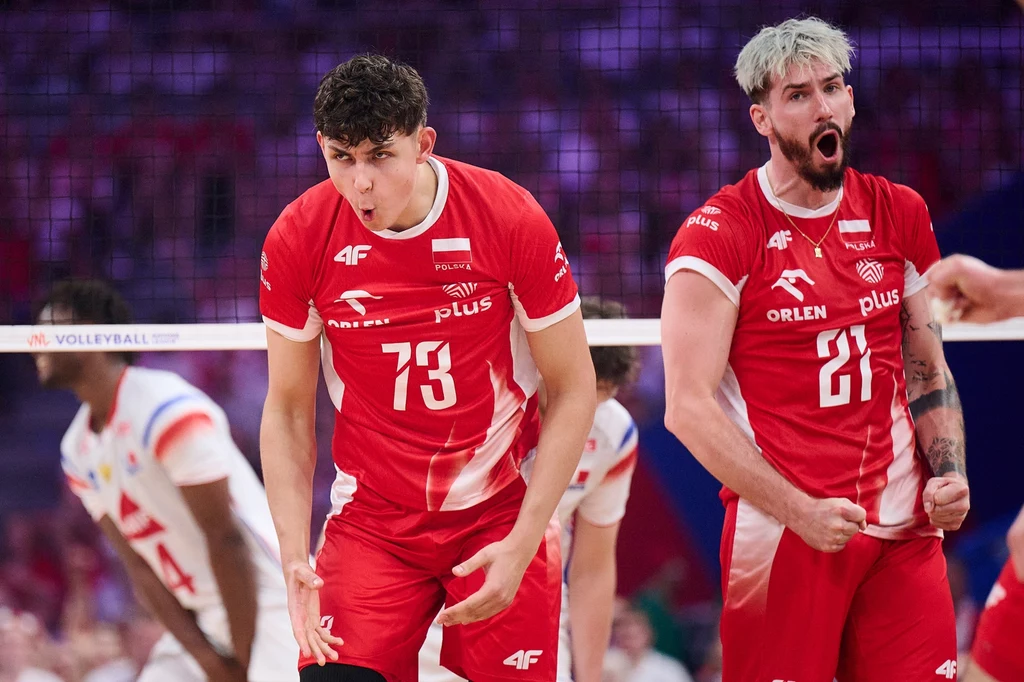 Jakub Nowak, obok Tomasz Fornal Dwóch siatkarzy w czerwonych strojach z orzełkiem na piersi wyraża silne emocje po udanej akcji na boisku, w tle widać rywali w białych strojach, wokół rozciąga się atmosfera intensywnej sportowej rywalizacji.