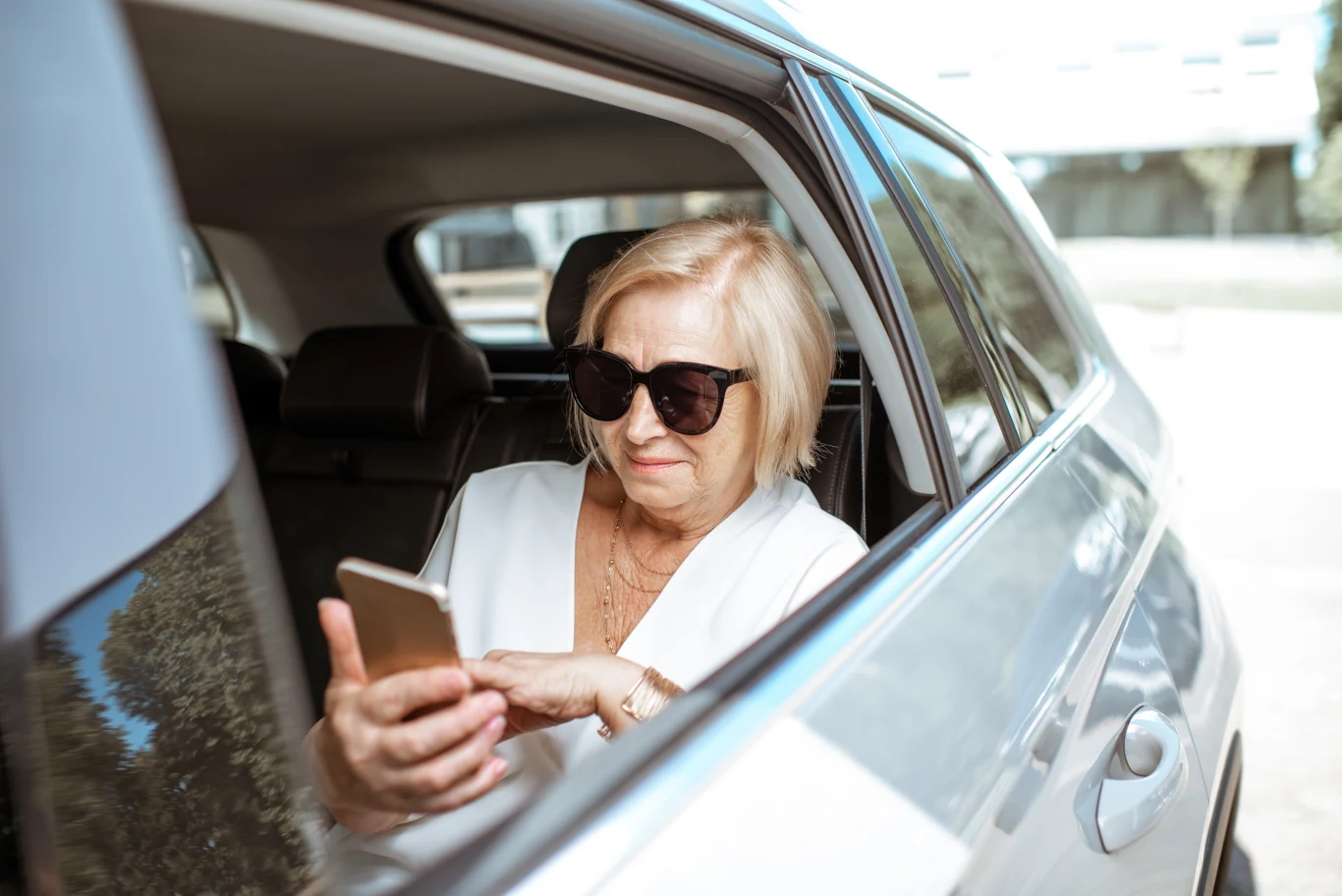 Program "Taksówka dla Seniora" już działa w kilku miastach w Polsce. Samochód oznaczony jako taksówka dla seniorów na ulicy w polskim mieście, program transportu dla osób starszych.