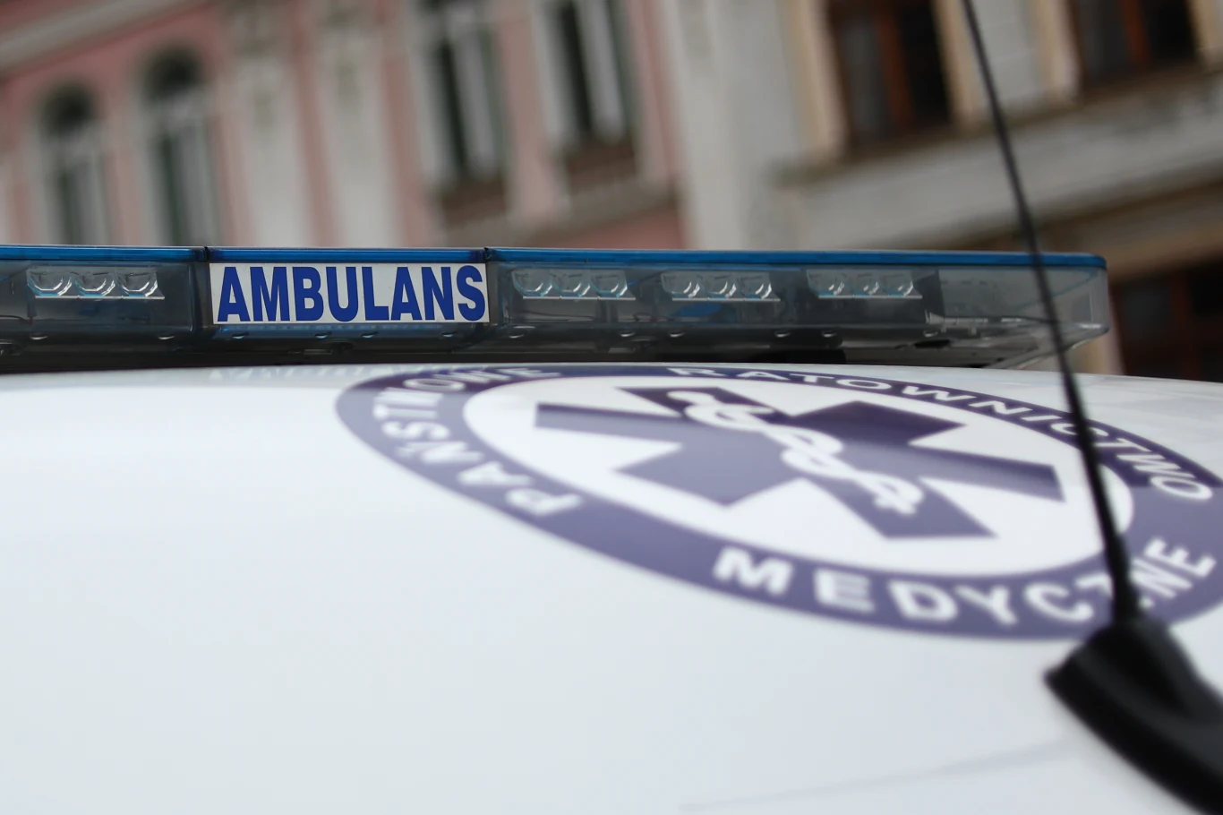 33-latek zaatakował ratowników medycznych Fragment ambulansu z niebieskim oznaczeniem nad szybą oraz charakterystycznym symbolem medycznym, w tle rozmazane fasady budynków miejskich.