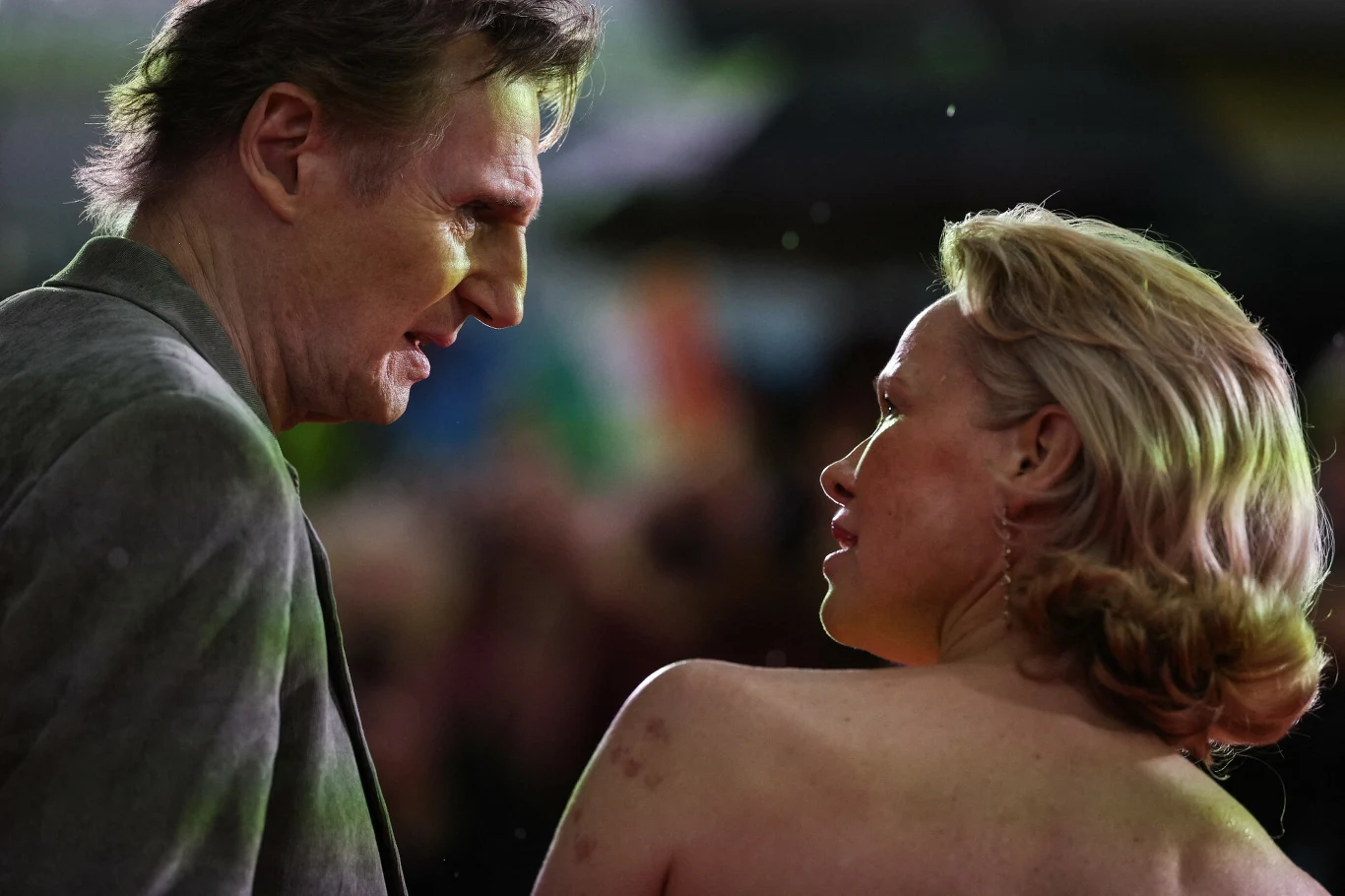 Pamela Anderson zaskoczyła na premierze filmu. Nie była tam sama Dwoje dorosłych ludzi stoi twarzą w twarz, prowadząc rozmowę, w tle widoczne kolorowe rozmyte światła i nieostre sylwetki.