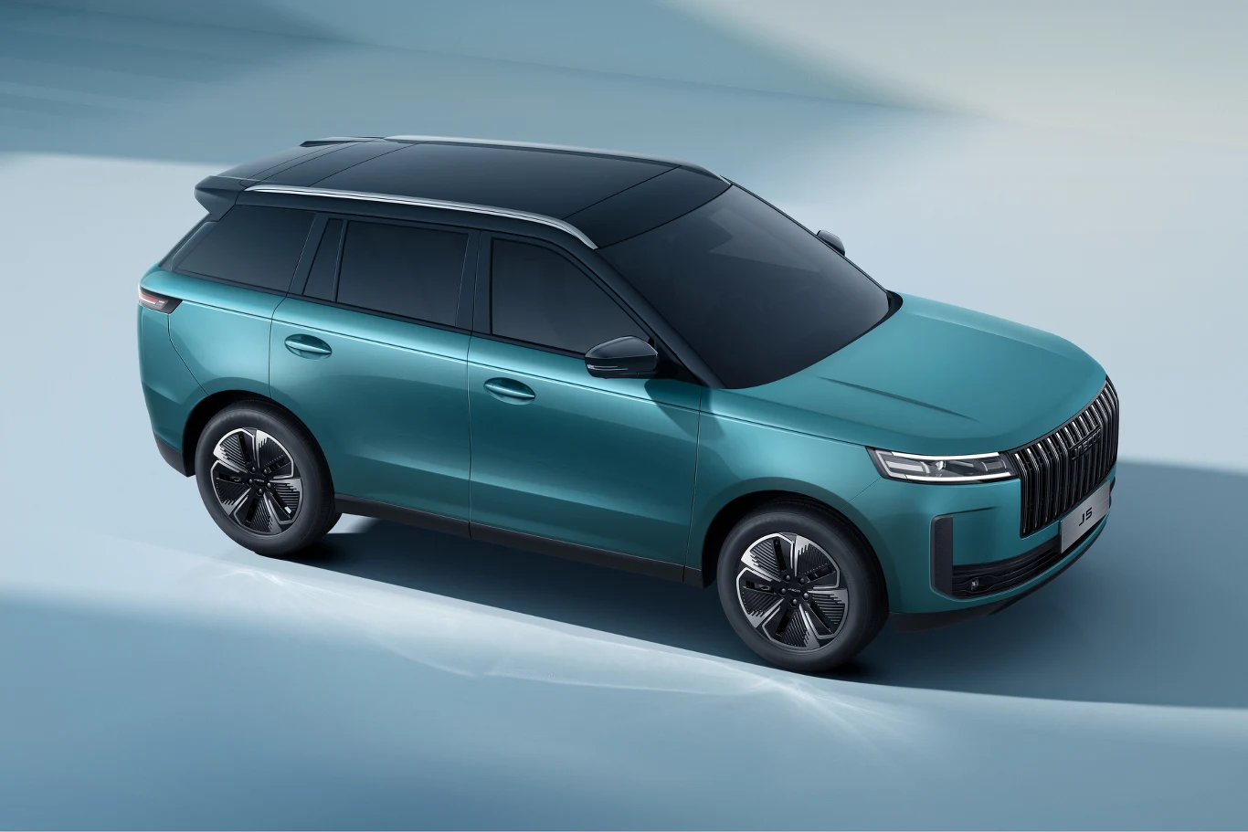 Nowoczesny SUV w kolorze turkusowym z przyciemnianymi szybami i czarnym panoramicznym dachem, ustawiony na jasnym tle, wyróżniający się eleganckimi liniami nadwozia i minimalistycznym stylem.