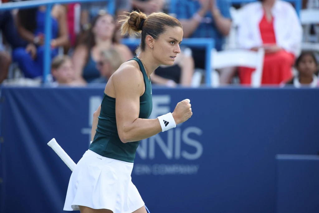 Maria Sakkari Zawodowa tenisistka w sportowym stroju świętuje zdobycie punktu na korcie podczas meczu, w tle widzowie na trybunach.
