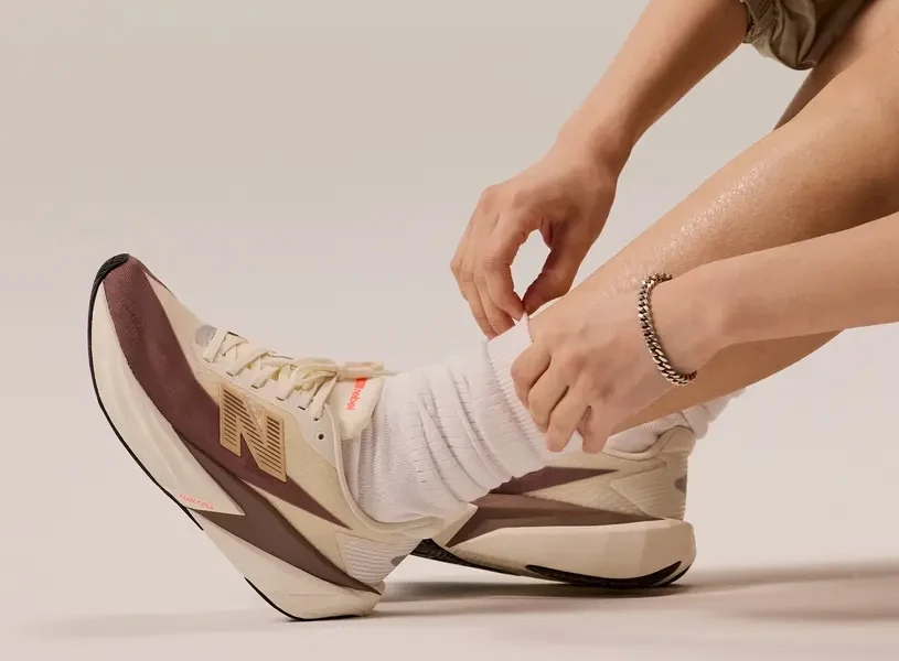 Osoba podwijająca skarpetki i mająca na sobie buty do biegania New Balance Rebel V5