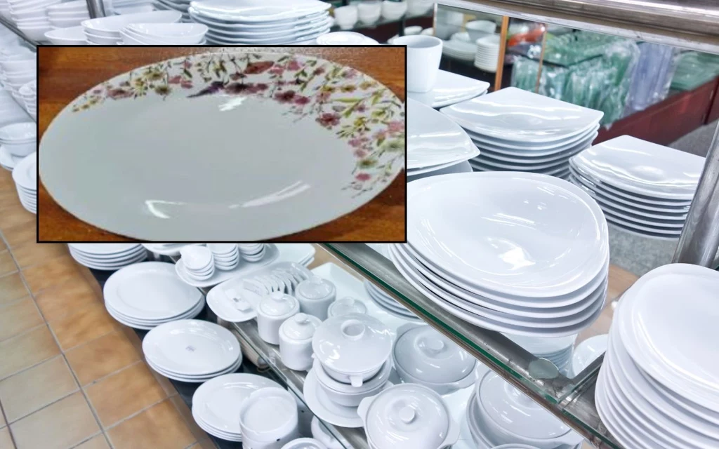 W zestawie naczyń stwierdzono wysoką migrację ołowiu - ostrzega GIS Stosy białych porcelanowych talerzy i naczyń ustawione na półkach sklepowych, na pierwszym planie owalny talerz z kolorowym, kwiatowym wzorem na brzegu.