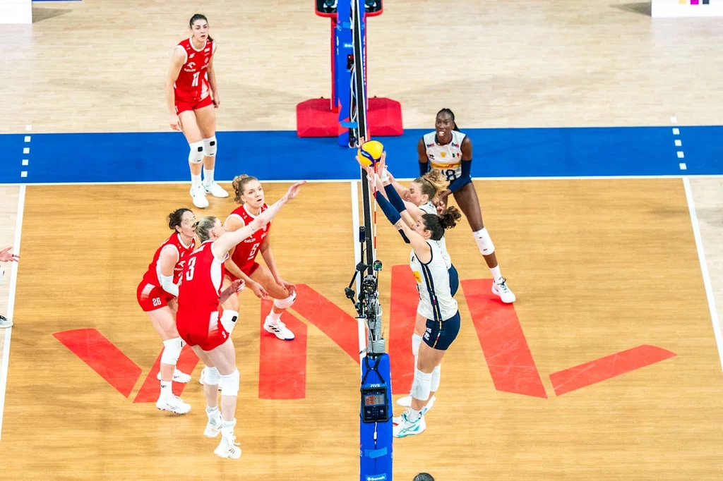 Liga Narodów siatkarek. Kadr z meczu Polska - Włochy Siatkówka kobiet, akcja przy siatce, zawodniczki dwóch drużyn rywalizują o piłkę przy bloku, dynamiczna atmosfera sportowej rywalizacji na hali.