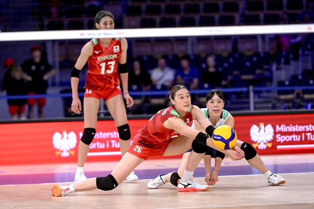 Siatkarki Japonii robiły, co mogły w obronie Zawodniczki drużyny Japonii ubrani w czerwone stroje sportowe podczas dynamicznej obrony w meczu siatkówki, jedna z nich wykonuje odbiór piłki w niskiej pozycji, a pozostałe dwie są przygotowane do kolejnej akcji.