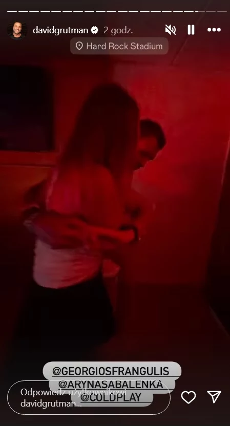 Dwie osoby obejmujące się w klubowej scenerii o czerwonym oświetleniu, w tle ciemne wnętrze.