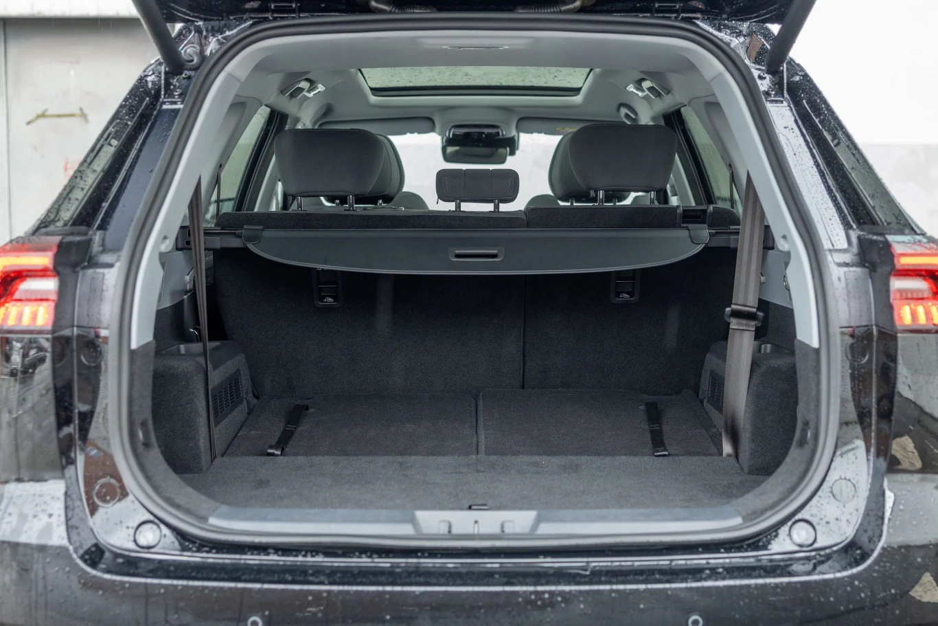 889 litrów. Bagażnik Chery Tiggo 8 robi wrażenie Otwarty bagażnik samochodu osobowego typu SUV z widocznymi złożonymi tylnymi siedzeniami i składanym schowkiem, wnętrze czyste i przestronne.