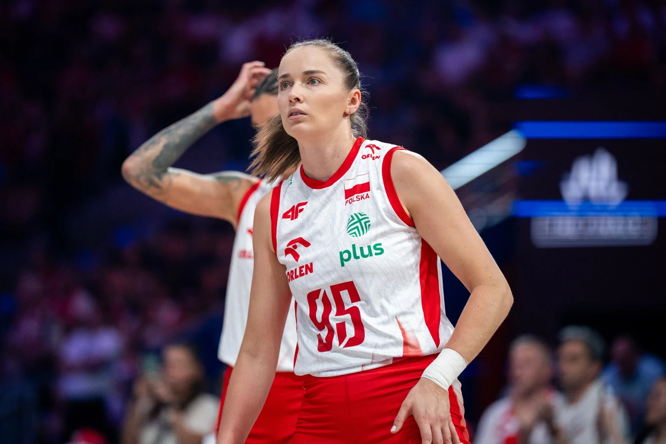 Magdalena Jurczyk Zawodniczka reprezentacji Polski w siatkówce w białoczerwonym stroju sportowym z numerem 95, stojąca na boisku podczas meczu, na tle rozmytej publiczności.