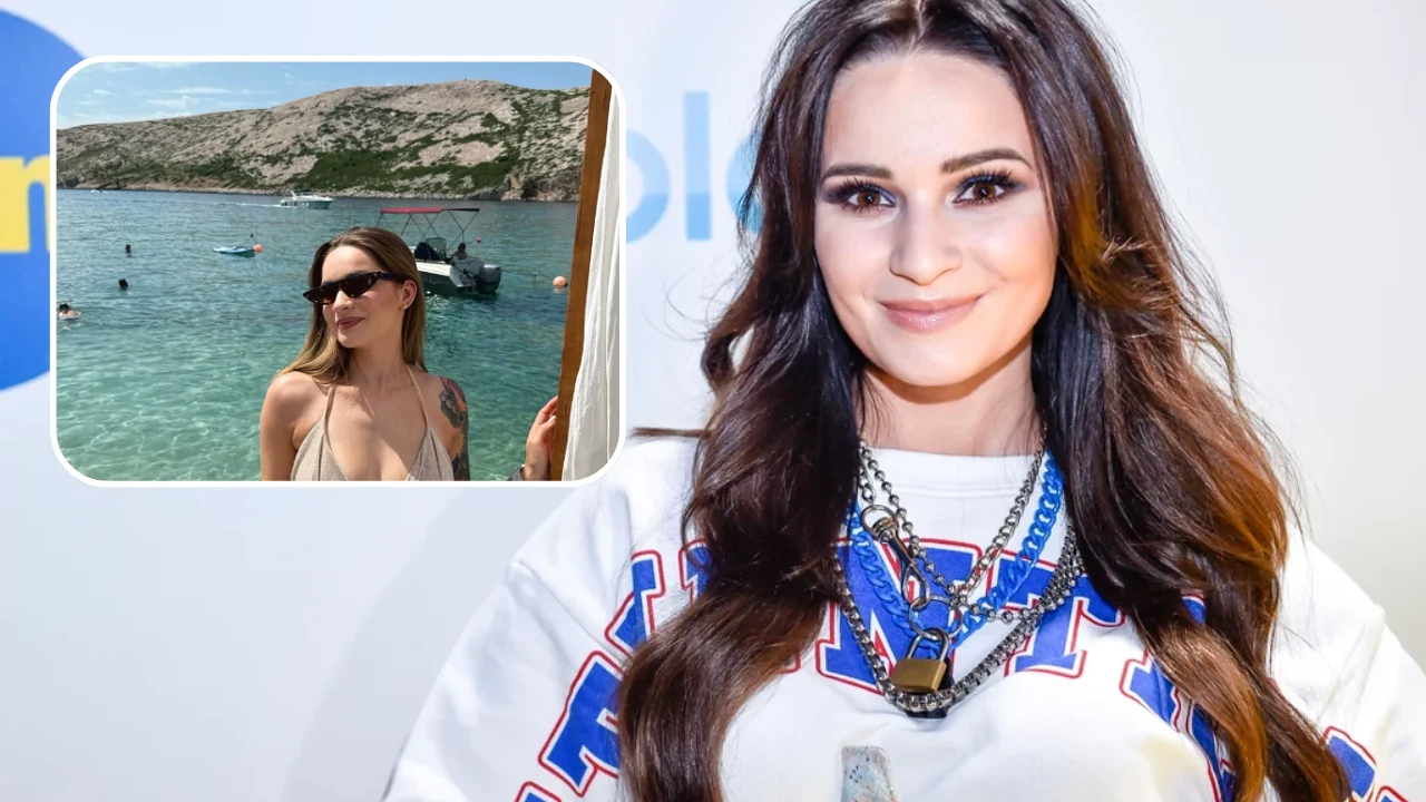 Uśmiechnięta kobieta z długimi, ciemnymi włosami ubrana w biały sweter z kolorowym nadrukiem, na szyi liczne naszyjniki; w rogu kadru widoczna mniejsza ramka z kobietą w okularach przeciwsłonecznych i bikini, na tle morza i skalistego wybrzeża.