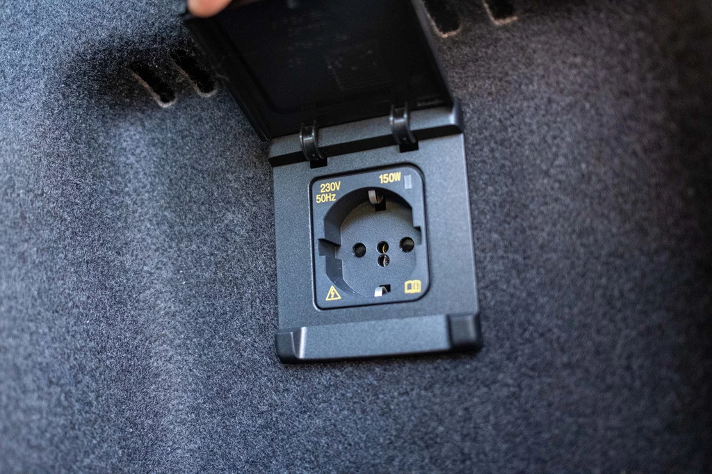 Gniazdo 230V w bagażniku pozwala podładować laptop czy inne urządzenia elektryczne. Gniazdko elektryczne 230V z osłoną umieszczone w otoczeniu wykładziny, przeznaczone do zasilania urządzeń o mocy do 150W.