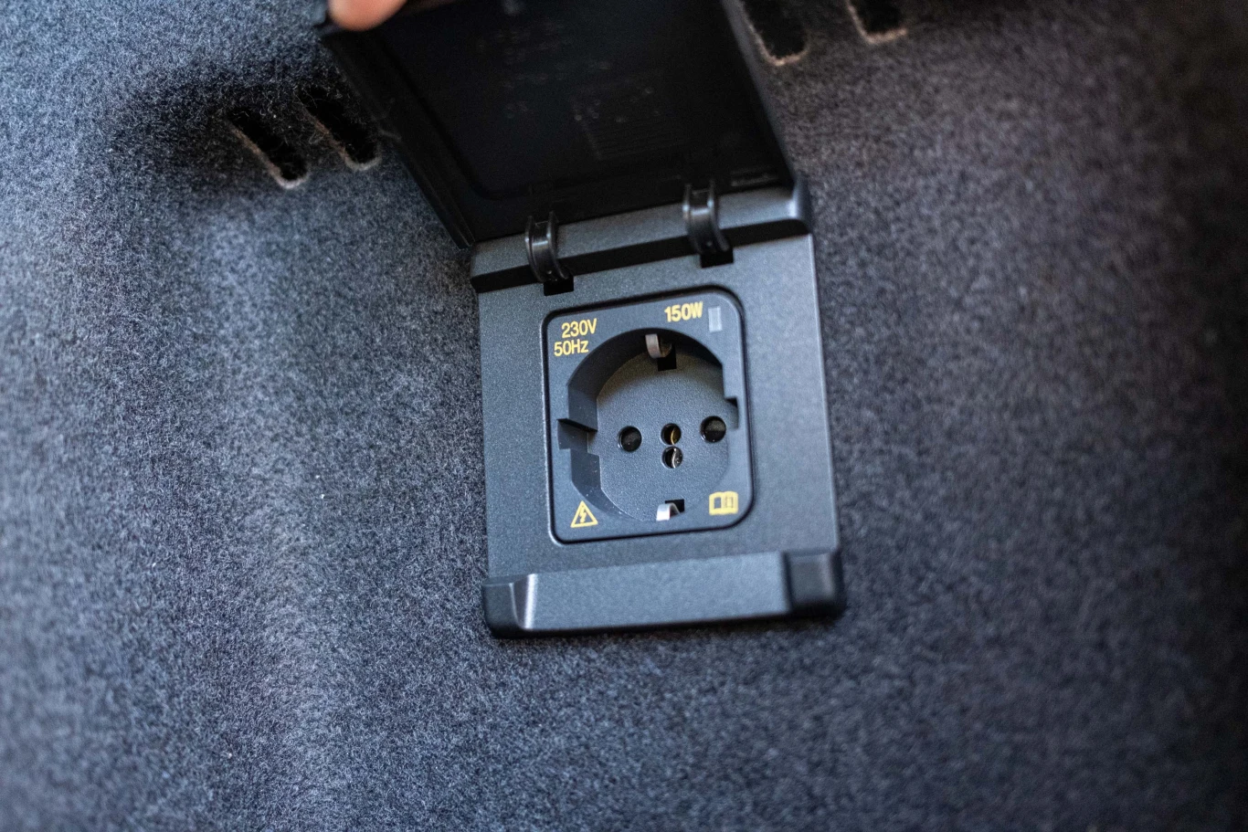 Gniazdo 230V w bagażniku pozwala podładować laptop czy inne urządzenia elektryczne. Gniazdko elektryczne 230V z osłoną umieszczone w otoczeniu wykładziny, przeznaczone do zasilania urządzeń o mocy do 150W.