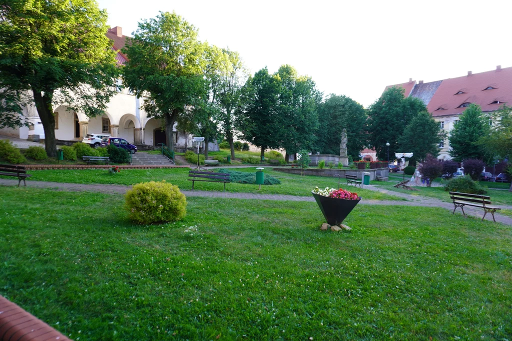 Chełmsko Śląskie może się poszczycić zielonym rynkiem, jaki trudno spotkać w jakimkolwiek innym miasteczku Zielony skwer miejski z alejkami spacerowymi i ławkami, na środku kwietnik w formie dużej donicy otoczony zadbaną trawą, w tle budynki mieszkalne oraz drzewa tworzące przyjemny cień.