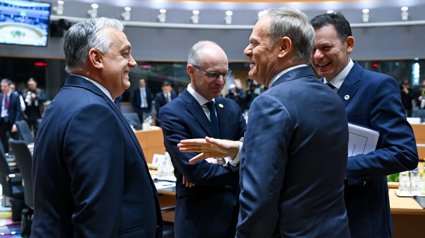 Viktor Orban w ostrych słowach skrytykował Donalda Tuska Grupa polityków w garniturach prowadzi rozmowę podczas oficjalnego spotkania na sali konferencyjnej, uśmiechy i gestykulacja wskazują na uprzejmą wymianę zdań.