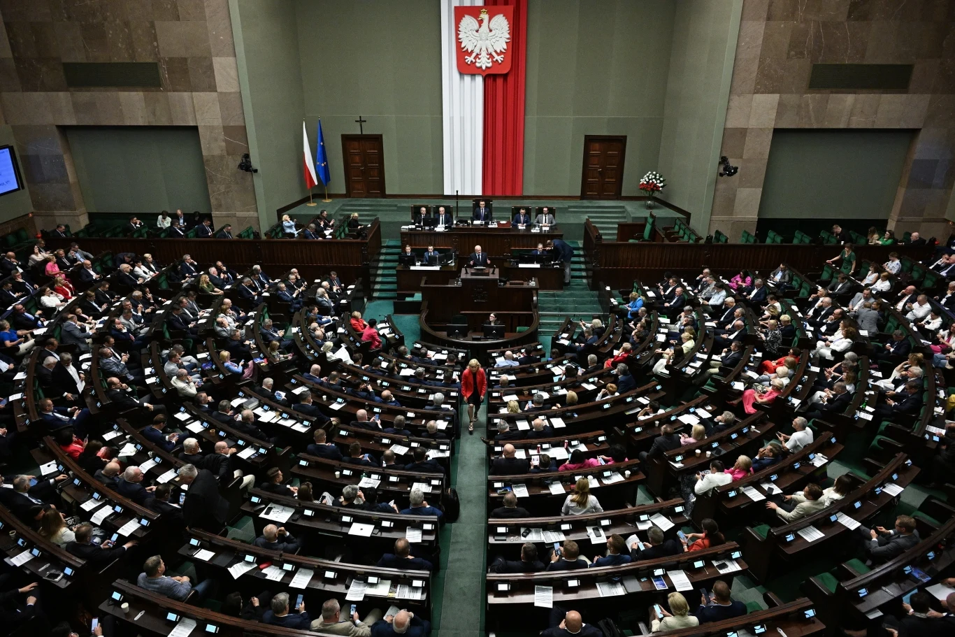 KO odnotowała duży skok w najnowszym sondażu partyjnym Wnętrze sali plenarnej polskiego Sejmu, ustawione półkoliście ławy zajęte przez licznych posłów, na ścianie wisi godło Polski oraz duża biało-czerwona flaga, z boku widoczne flagi Polski i Unii Europejskiej.