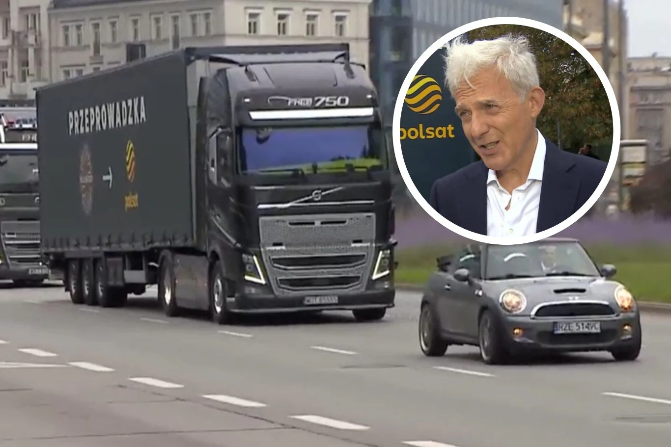 Nietypowa akcja promocyjna w Warszawie. Tak wyglądała przeprowadzka Milionerów Czarny samochód ciężarowy Volvo z napisem "przeprowadzka" i logo telewizji Polsat jedzie ulicą obok osobowego auta mini cooper; na okrągłym wstawieniu portret starszego mężczyzny z siwymi włosami w garniturze, na tle logotypu Polsatu.