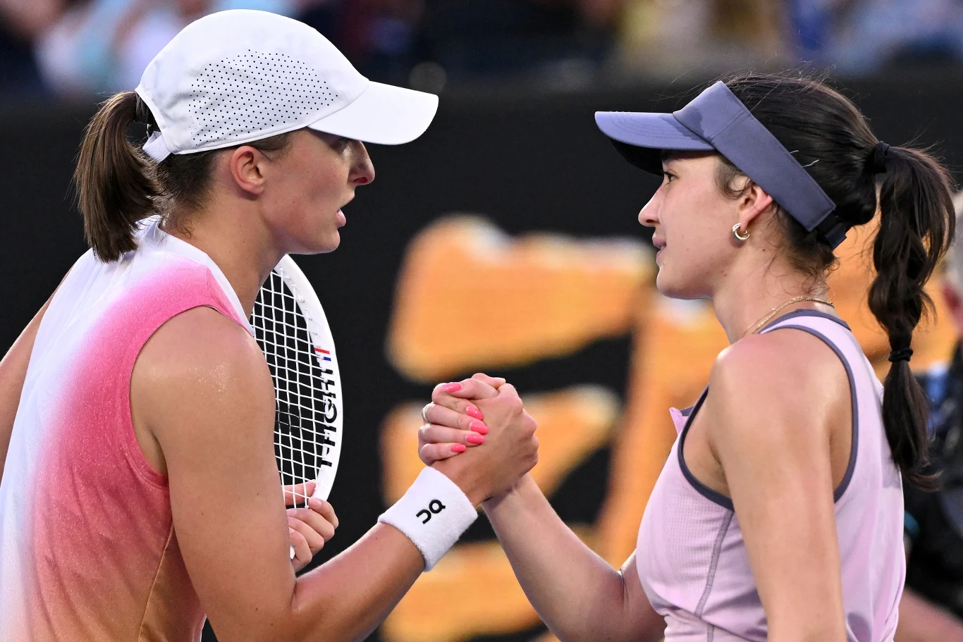 Iga Świątek, Eva Lys Dwie tenisistki ściskają sobie dłonie na korcie po zakończonym meczu, obie ubrane w sportowe stroje, widoczne rakiety tenisowe oraz wyraz wzajemnego szacunku i sportowej rywalizacji.