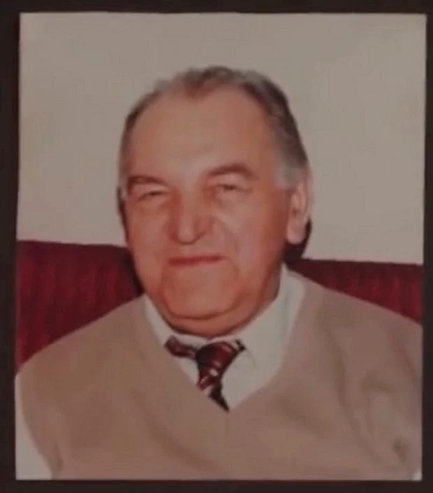 Zdzisław Rąbiński ps. "Rębacz", dziadek Andrzeja Wrony Starszy mężczyzna z siwymi włosami, w jasnej kamizelce i koszuli z krawatem, uśmiecha się lekko siedząc na tle czerwonego oparcia.