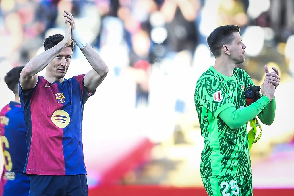 Robert Lewandowski i Wojciech Szczęsny Dwóch piłkarzy na pierwszym planie, jeden ubrany w czerwono-niebieską koszulkę FC Barcelona z uniesionymi rękami, drugi w zielonym stroju bramkarskim klaszcze; w tle rozmyte sylwetki oraz trybuny stadionu.