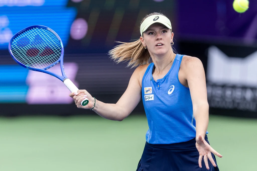 Martyna Kubka Tenisistka w niebieskim stroju wykonuje forehend na korcie podczas meczu tenisowego, skoncentrowana na poruszającej się piłce.