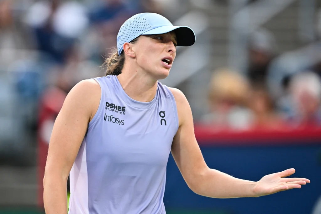 IGA świątek contributed with Clara Tauson for the promotion of the WTA 1000-finale district in Montreal A tennis player in a sporting outfit has gestures in a field match, in the context of blurred stands.
