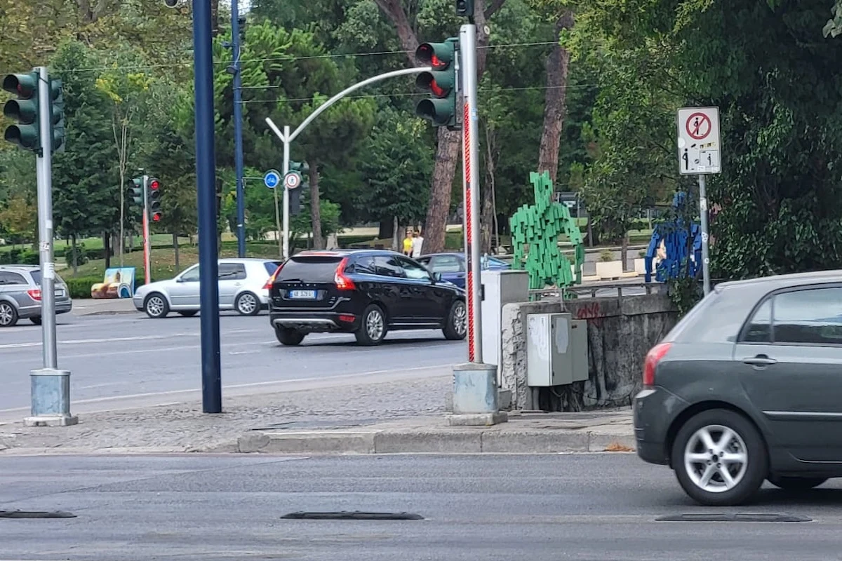 Gdy na czerwono świeci się cały słupek, trudno o tłumaczenie, że "nie zauważyłem" Ruchliwe skrzyżowanie z kilkoma samochodami, sygnalizacja świetlna oraz znak zakazu umieszczony przy jezdni; w tle widoczna zieleń i drzewa.