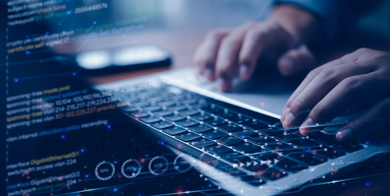 Wykorzystali AI i stracili kontakt. Pierwszy taki wyrok w Polsce. Dłonie osoby piszącej na klawiaturze laptopa, nałożony cyfrowo kod komputerowy i wykresy, co sugeruje pracę programistyczną lub analizę danych.