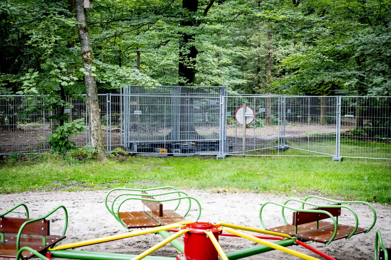 Plac zabaw otoczony płotami, znajdujący się przy Piramidzie Austerlitz, gdzie w pobliżu prawdopodobnie doszło do ataku wilka, który zranił 6-letniego chłopca. Karuzela dziecięca na placu zabaw otoczonym metalowym ogrodzeniem, w tle las i zamknięty dostęp do dalszej części terenu