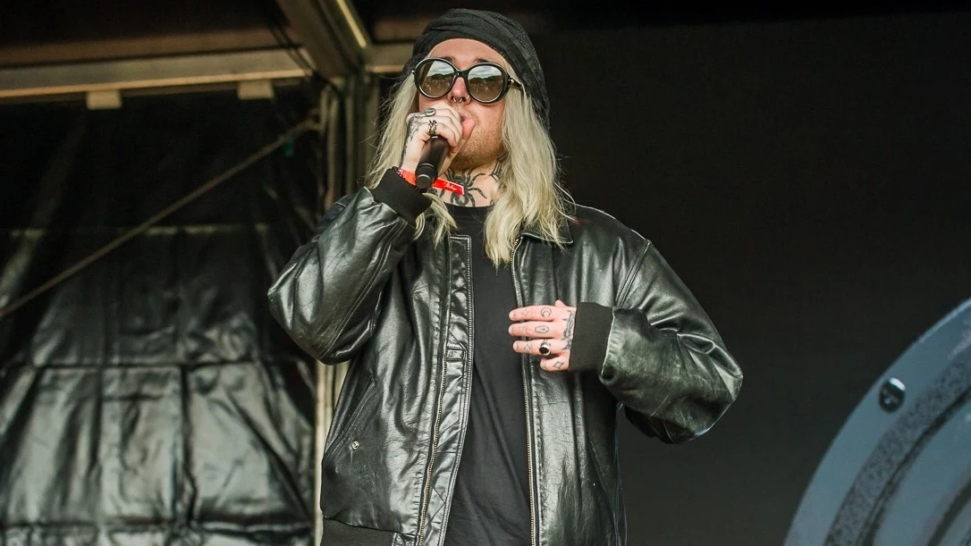 Leo Ros zagrał na OFF Festivalu Młody mężczyzna z długimi blond włosami, w ciemnych okularach przeciwsłonecznych i czarnej skórzanej kurtce wykonuje utwór na scenie, trzymając mikrofon w prawej ręce.