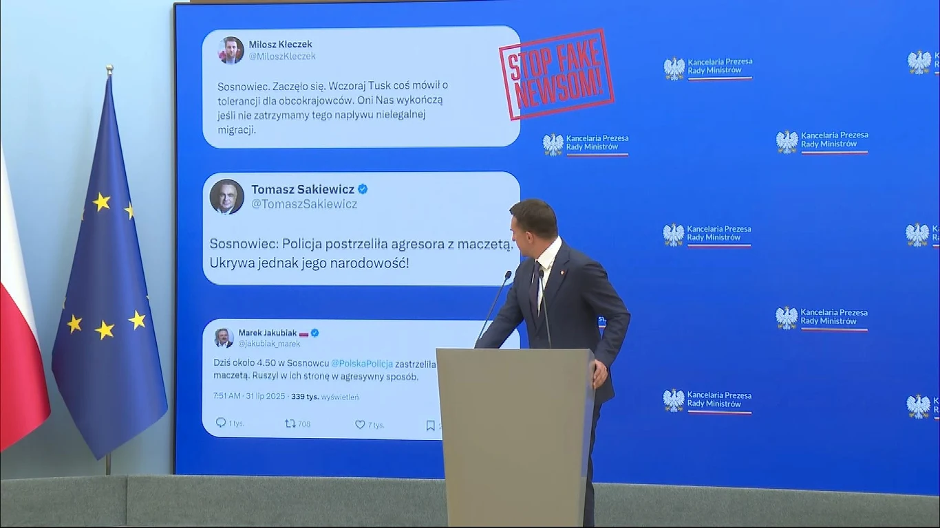 Rzecznik rządu Adam Szłapka Mężczyzna w garniturze stoi przy mównicy na tle dużego ekranu, na którym wyświetlone są tweety dotyczące wydarzeń w Sosnowcu oraz napis 'STOP FAKE NEWSOM'. Obok znajdują się flagi Polski oraz Unii Europejskiej, a całość ma oficjalny charakter konferenc...