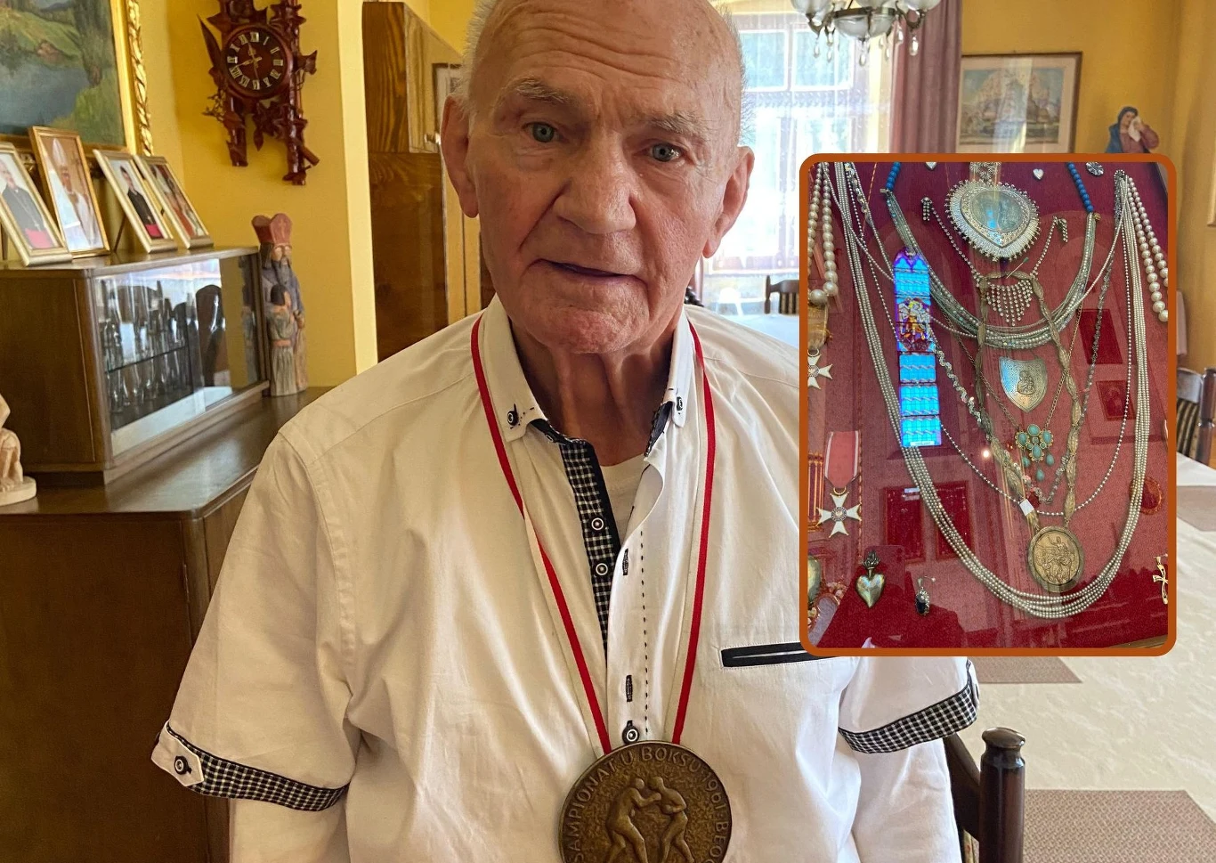 Marian Kasprzyk, w ramce jego wotum w sanktuarium Starszy mężczyzna w białej koszuli nosi na szyi duży medal, na tle eleganckiego, domowego wnętrza z rodzinnymi zdjęciami oraz dekoracjami. Wstawka pokazuje kolekcję medali, łańcuchów i odznaczeń ułożonych na czerwonym materiale.
