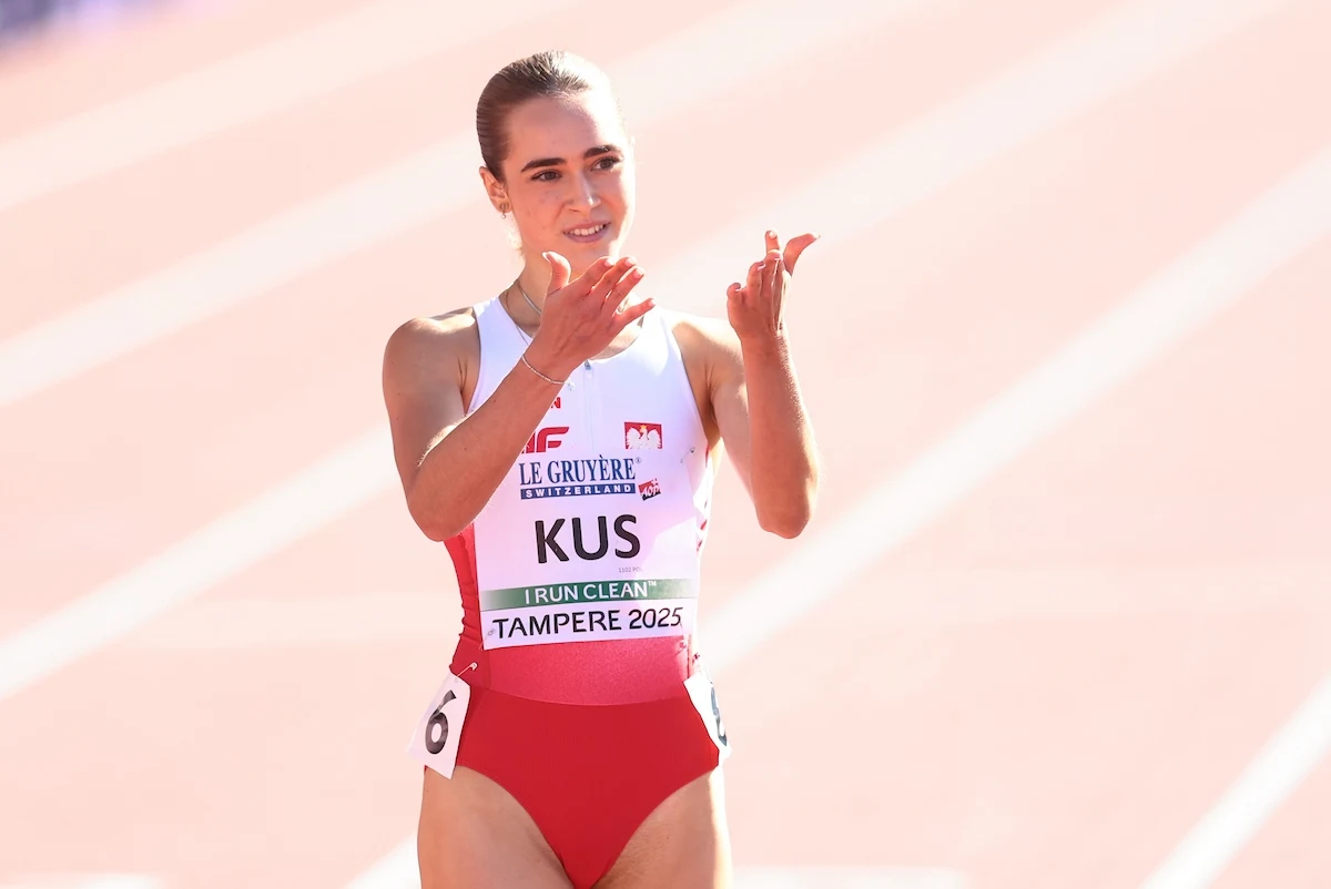 Anastazja Kuś Lekkoatletka w stroju reprezentacyjnym Polski na stadionie podczas zawodów, klaszcze w dłoniach, wyraża radość lub uznanie.