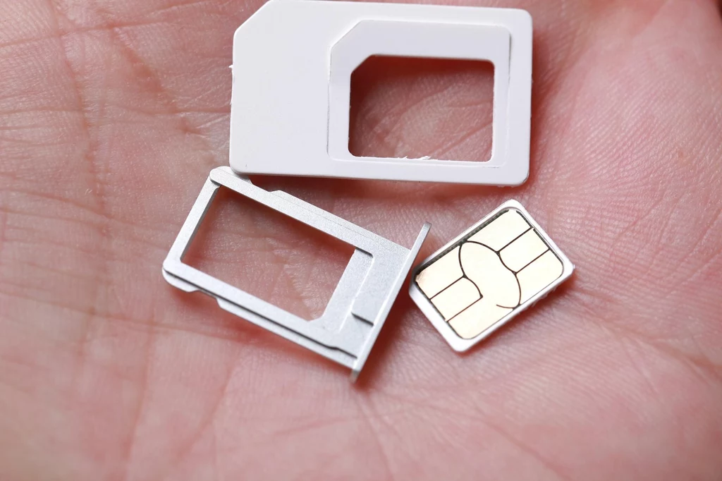 Abonament często oferuje szerszy pakiet korzyści Miniaturowa karta SIM, taca na kartę SIM oraz adapter do różnych rozmiarów kart ułożone na otwartej dłoni człowieka.
