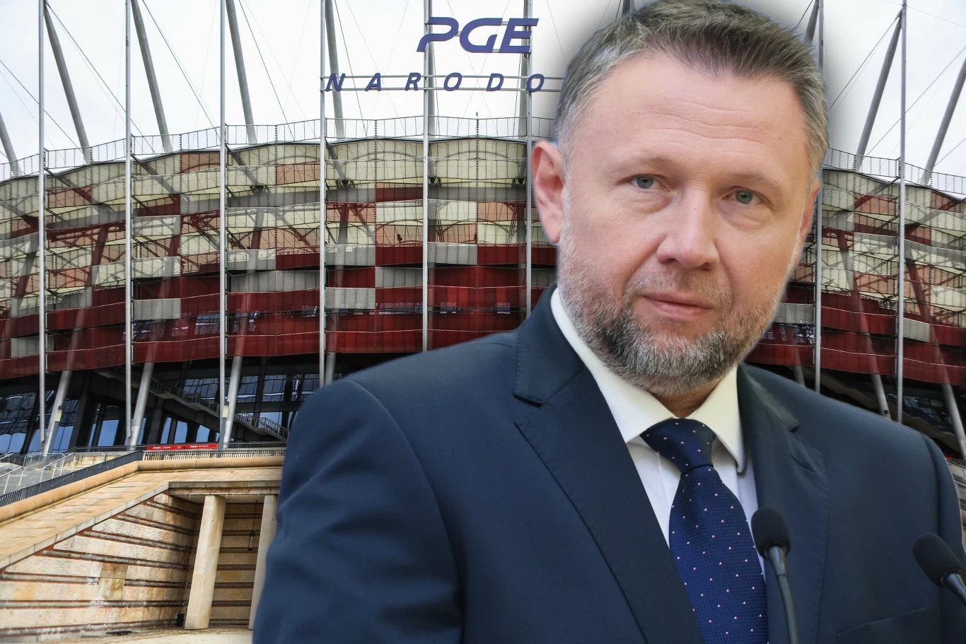Marcin Kierwiński reaguje w sprawie incydentów na PGE Narodowym Mężczyzna w garniturze i krawacie stoi przed Stadionem Narodowym PGE, widoczny napis nad trybunami oraz charakterystyczna konstrukcja stadionu.