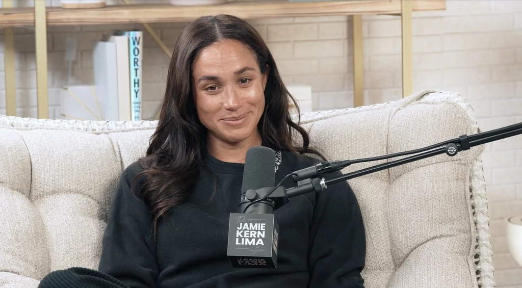 Program Meghan spotkał się ze sporą krytyką, dlatego drugi jego sezon jest sporym zaskoczeniem Kobieta o długich, ciemnych włosach siedzi na kremowej sofie podczas nagrania podcastu, ubrana w czarną bluzę, trzyma mikrofon z napisem Jamie Kern Lima, w tle półki z książkami i jasna ściana.