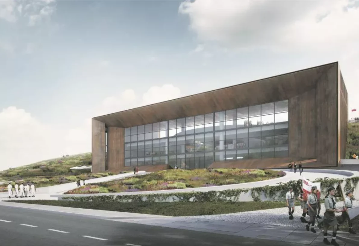 Otwarcie Muzeum Bitwy Warszawskiej w Ossowie już 16 sierpnia Nowoczesny budynek o prostych liniach z dużymi przeszklonymi oknami ulokowany na lekko wzniesionym terenie, z ograniczoną roślinnością i kilkoma grupami ludzi spacerujących po wyznaczonych ścieżkach.