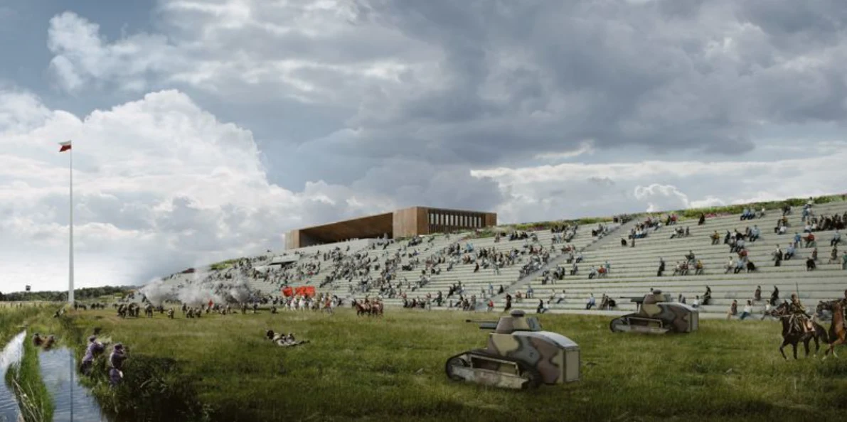Otwarcie Muzeum Bitwy Warszawskiej i rekonstrukcja w Ossowie Szerokie schody z betonu pełnią funkcję trybun, na których siedzą liczne osoby; na zielonym terenie poniżej pojazdy wojskowe, kilku żołnierzy oraz jeźdźcy konni, całość pod pochmurnym niebem, w tle nowoczesny budynek i maszt z flagą.