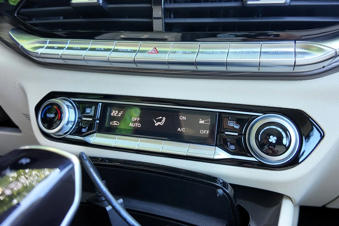 Panel sterowania klimatyzacją w samochodzie z cyfrowym wyświetlaczem pokazującym ustawienie temperatury na 22,5°C oraz przyciskami do regulacji nawiewu, klimatyzacji i trybu auto.
