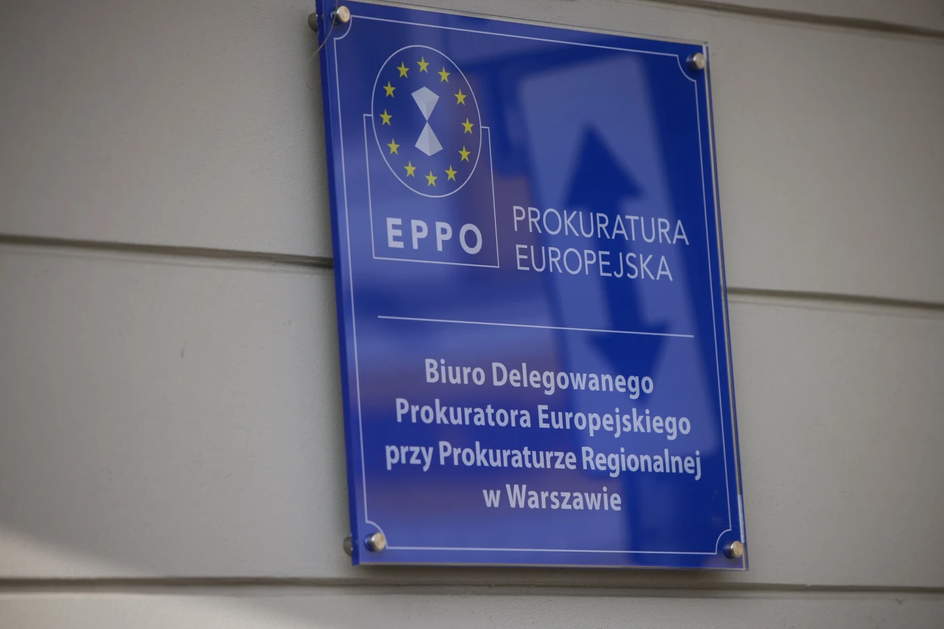 Prokuratura Europejska wszczęła postępowanie w sprawie afery KPO Niebieska tablica informacyjna EPPO z napisem Prokuratura Europejska oraz opisem Biura Delegowanego Prokuratora Europejskiego przy Prokuraturze Regionalnej w Warszawie, zamontowana na ścianie budynku.